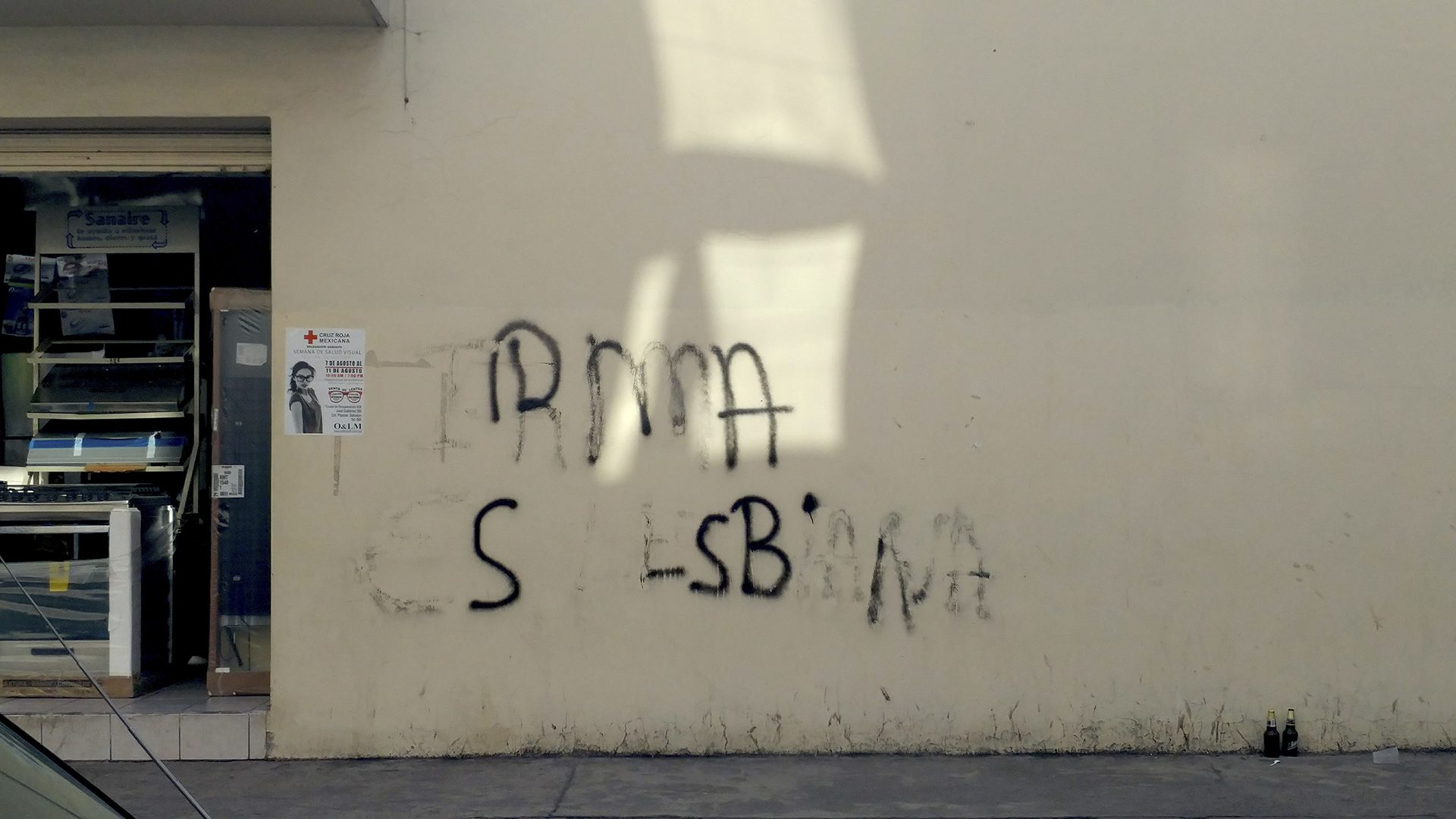 "Irma es lesbiana" written on a beige wall in black
