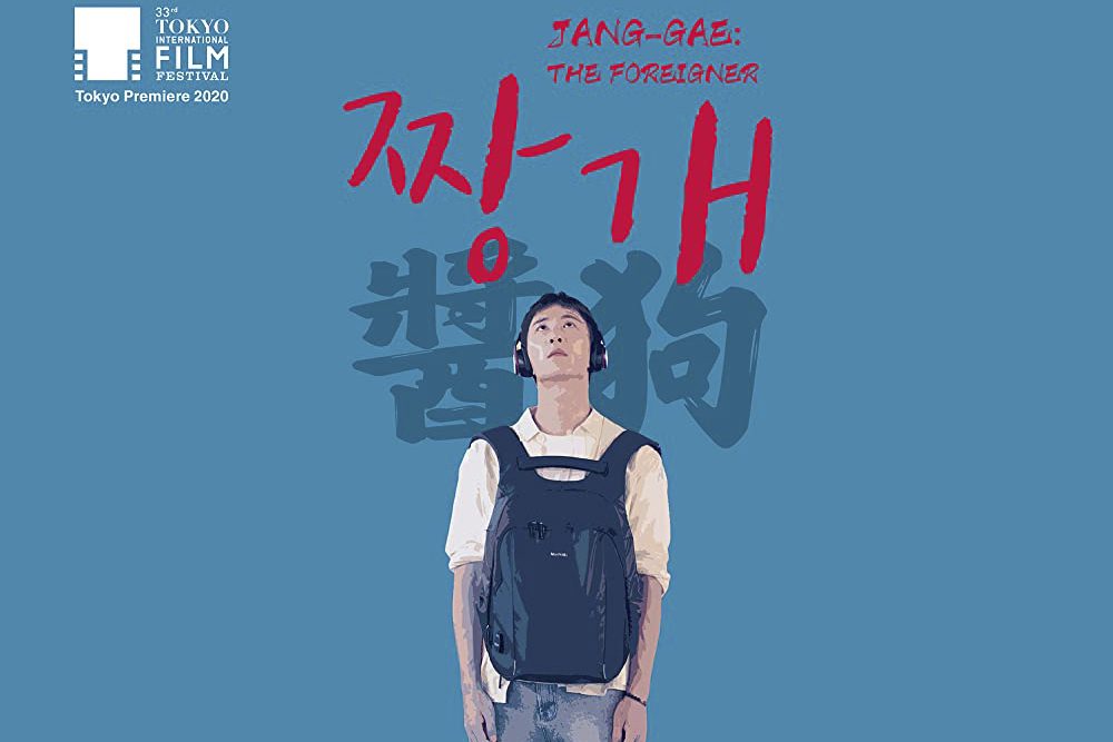 Proyección de la película - Jang-Gae: The Foreigner; chico con mochila delante y auriculares puestos mirando hacia arriba