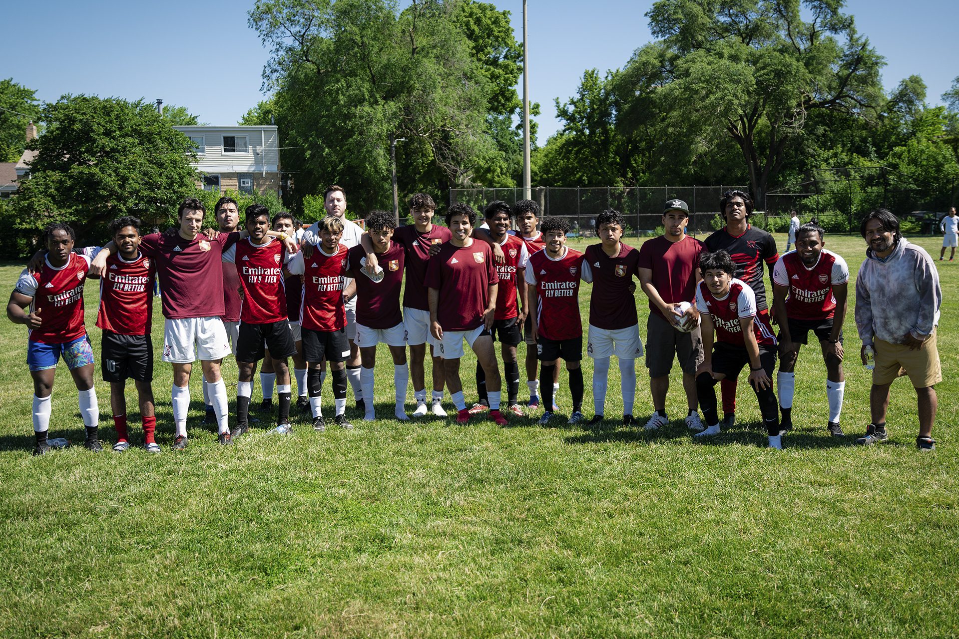 grupo de jugadores de fútbol en un campo; la mayoría llevan camisetas rojas