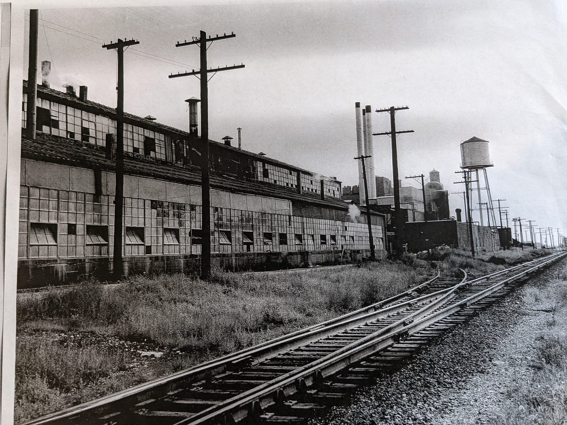 Black and white photo of the closed Kerr-McGee factory next to railroad tracks in West Chicago