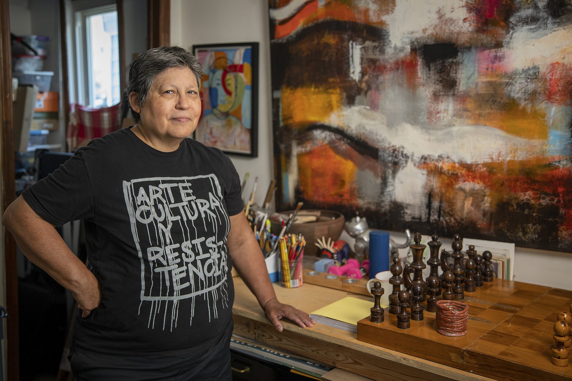 Diana Solis in her home with paintings and chess set