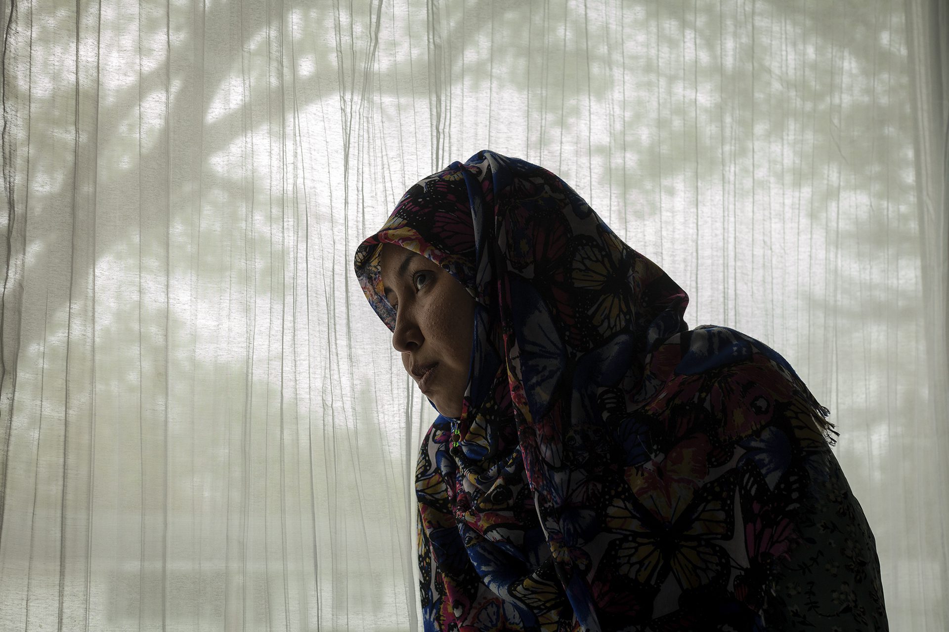 Salima Mazari mirando por la ventana de su actual casa