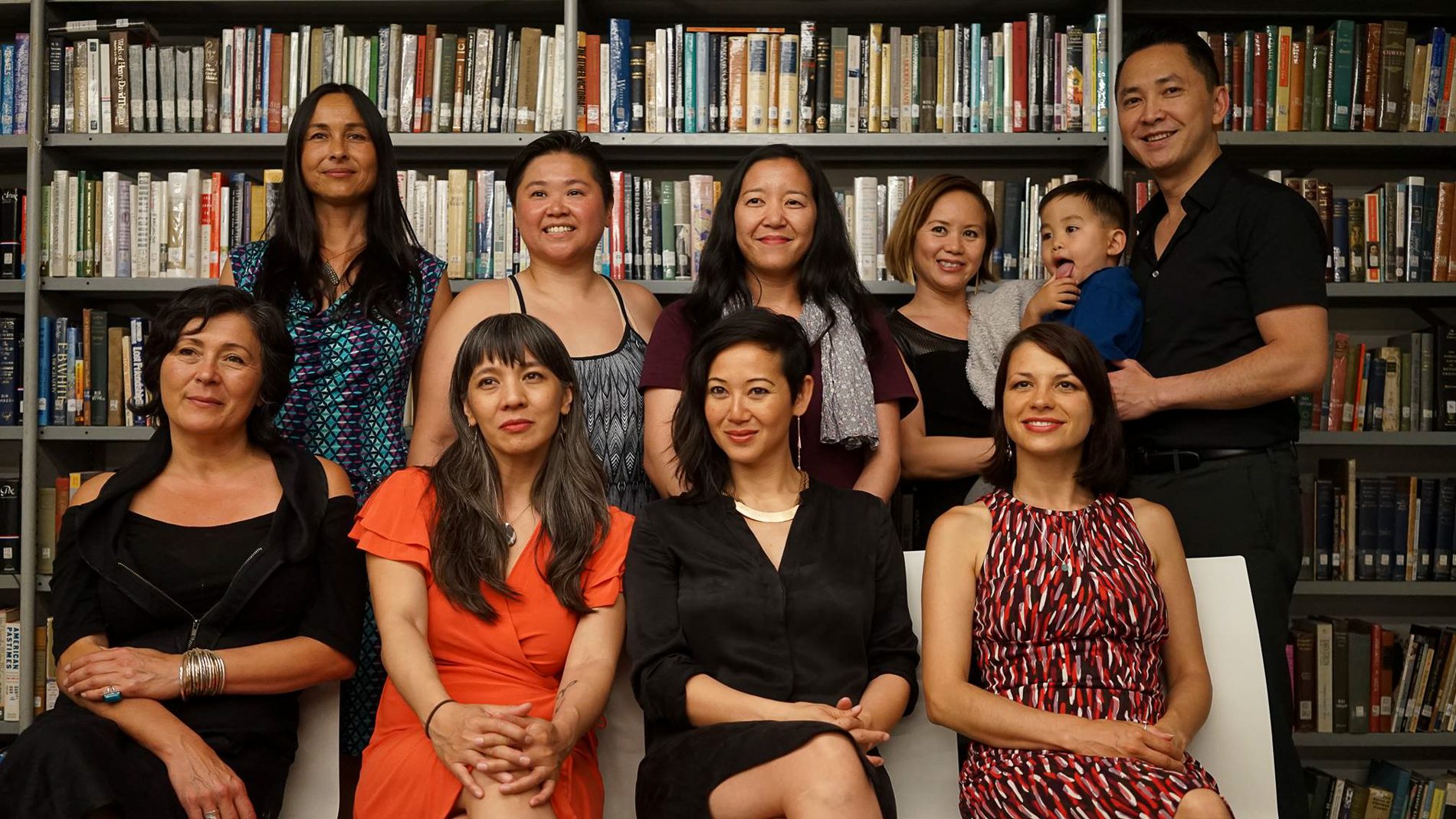 A group of ten with book shelves in the background