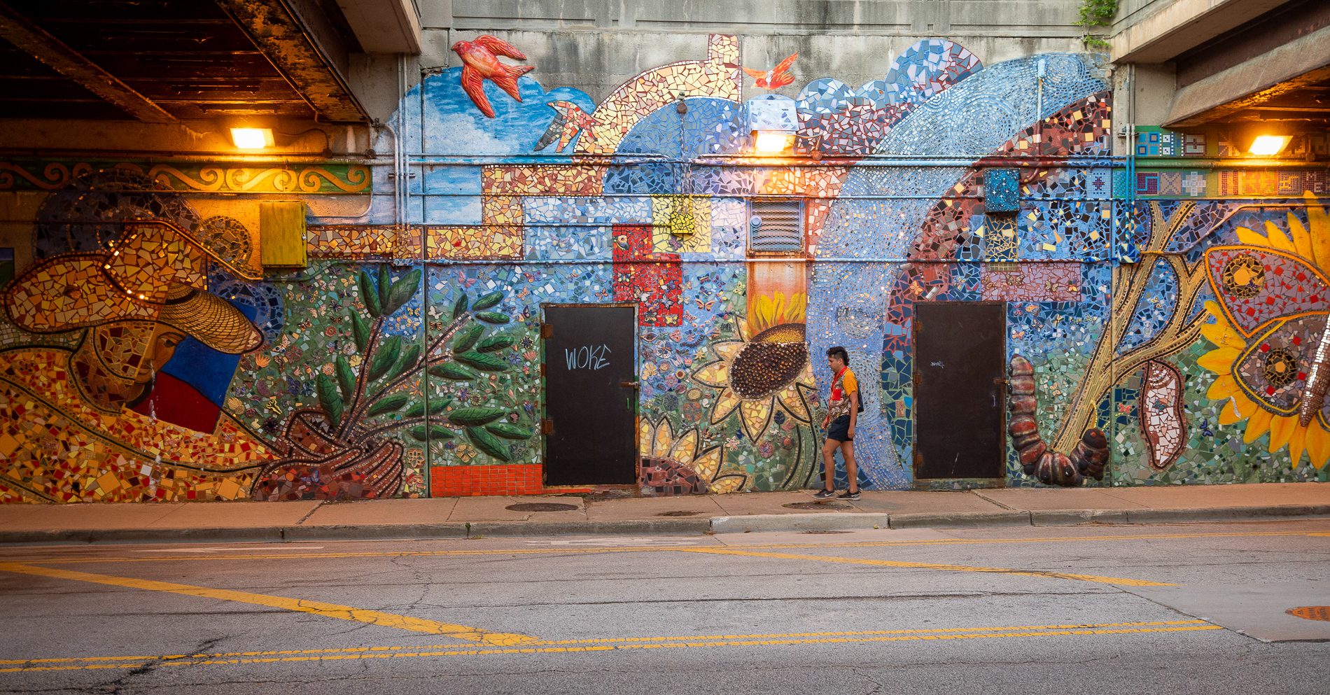 J Saxon walks past a colorful mural in the Edgewater