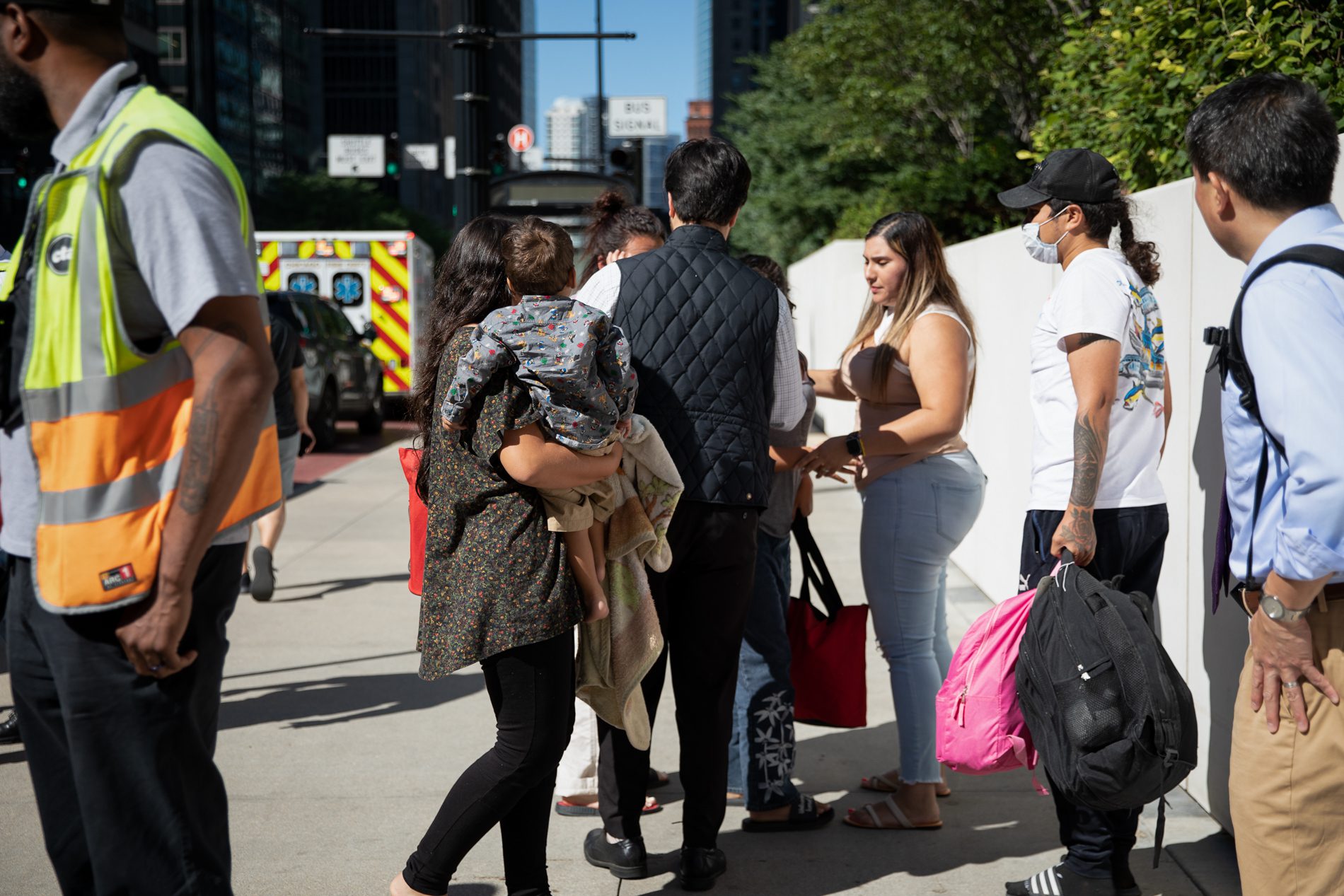 Migrants walk to a city bus after being sent to Chicago from Texas by Gov. Greg Abbott