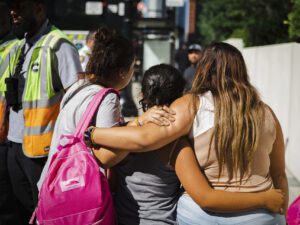 Migrants hub by a bus after being sent to Chicago from Texas by Gov. Greg Abbott