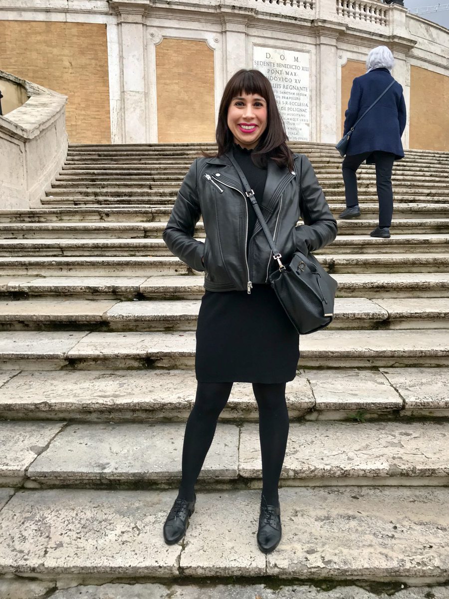 foto de Erika L. Sánchez vestida de negro y sonriendo en las escaleras