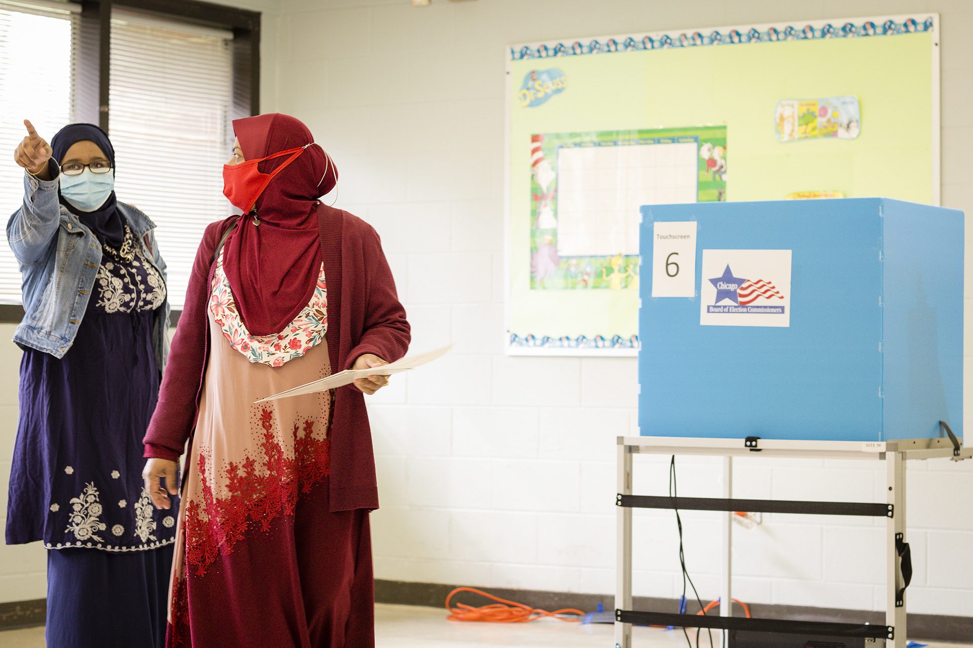 Una mujer con un hijab rojo vota