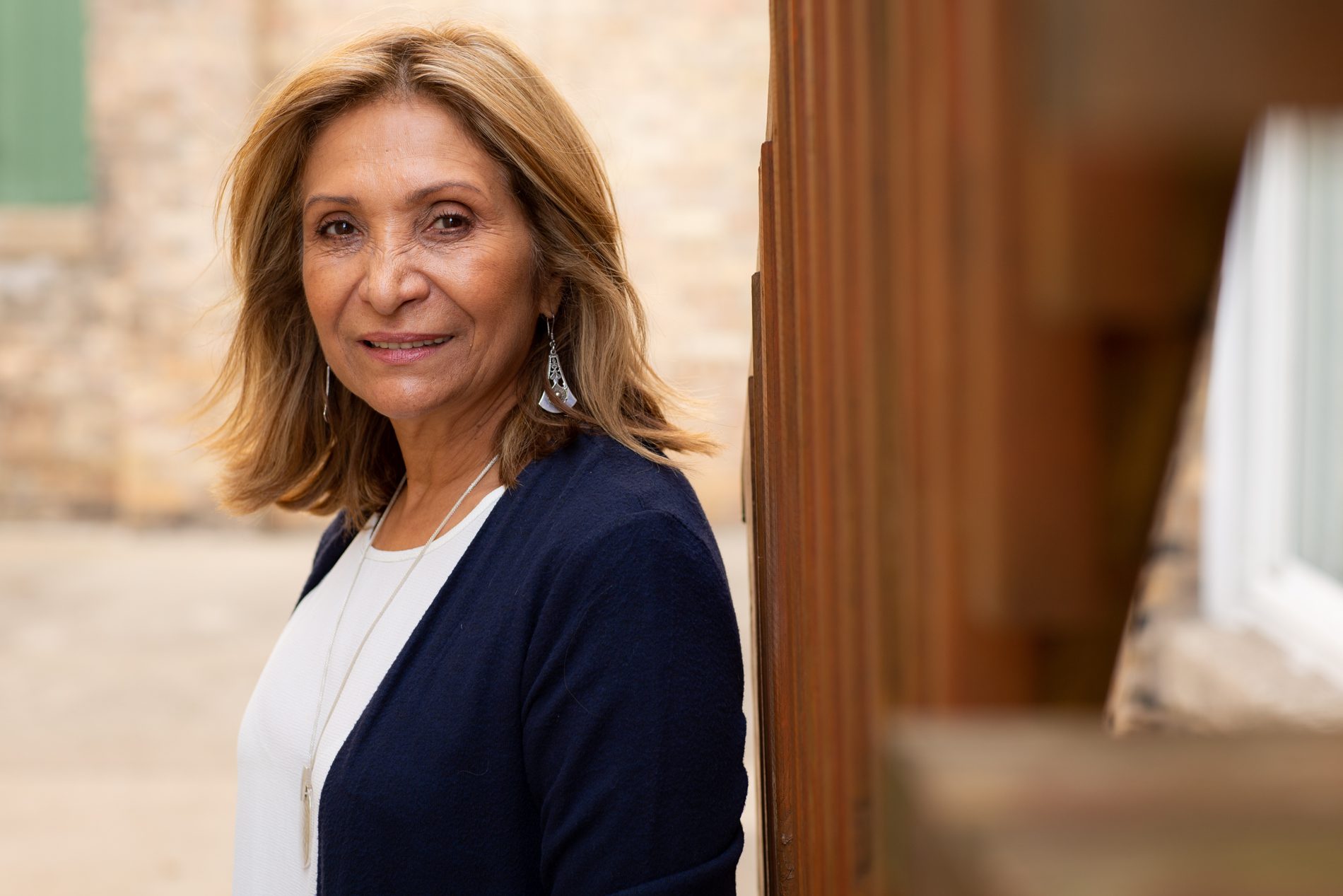 Ana Gil outside wearing a white blouse and blue jacket