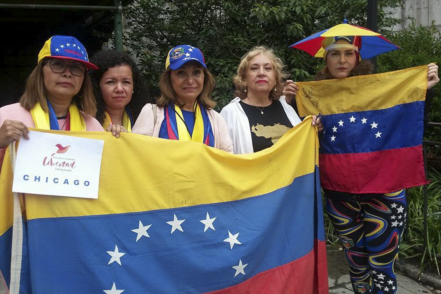 five women weaing Venezuelan colors and holding Venezuelan flags face the camera
