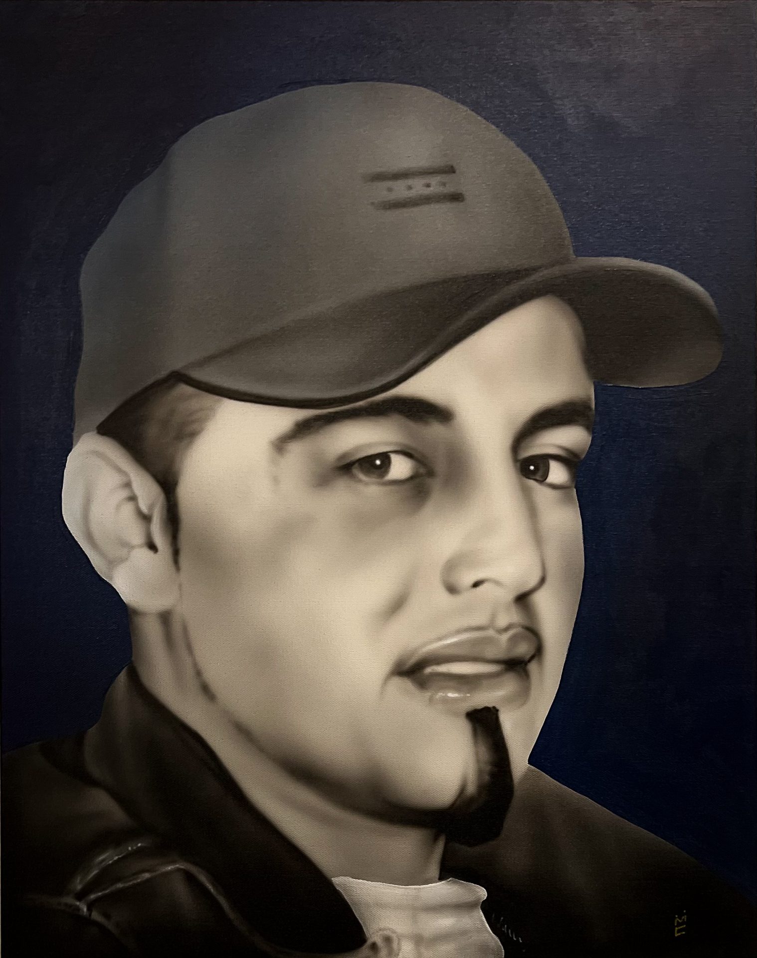 Luis Santillan wearing a cap sepia on a blue background