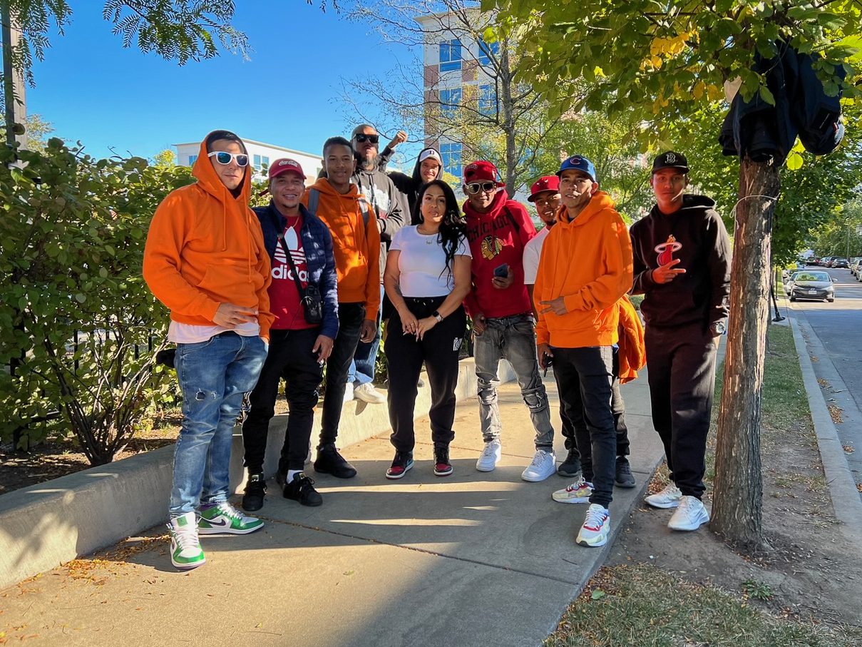 ten people stand outside o the sidewalk in various types of shirts and hoodies